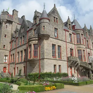 The sandstone towers and turrets of Belfast Castle above its formal garden
