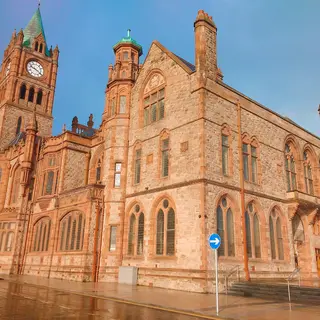 The red sandstone Guildhall in Derry with its clock tower, on a wet evening