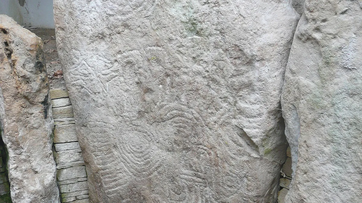A tall chamber stone at Knockmany carved all over with faint circles and spirals
