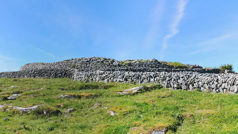 The round dry stone wall of Caherconnell Stone Fort on the Burren grassland