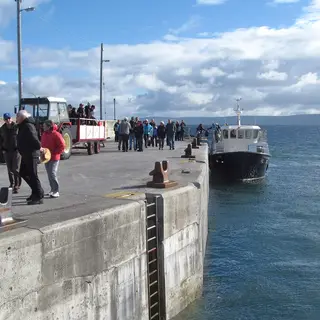 Passengers walking along the pier as the ferry comes in to Inis Oírr
