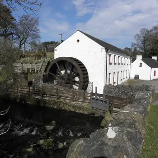 The whitewashed mill at Wellbrook with its big iron water wheel above the river
