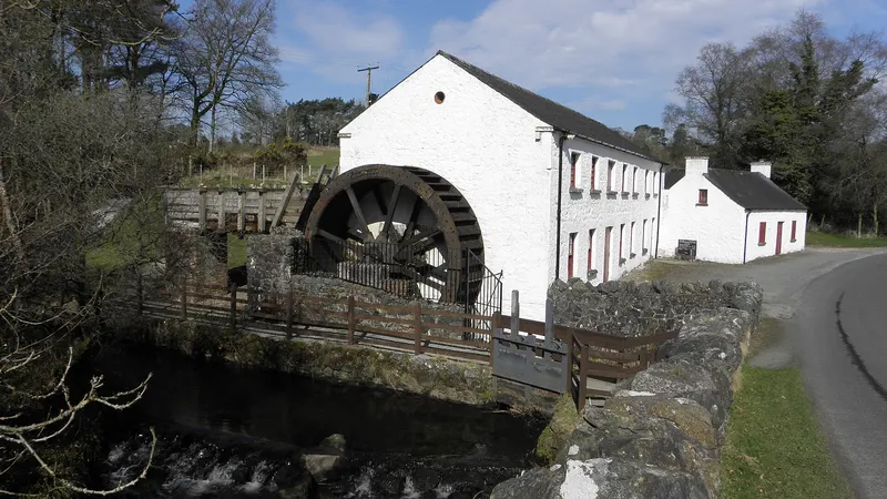 The whitewashed mill at Wellbrook with its big iron water wheel above the river