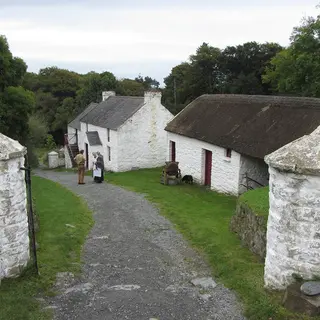 Whitewashed thatched farm buildings along a lane at the Ulster Folk Museum