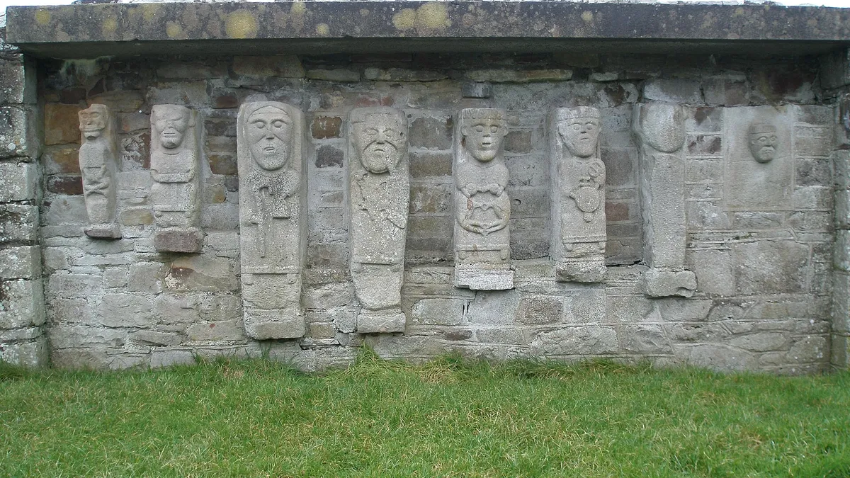 Eight carved stone figures set in a row into the wall of the ruined church on White Island