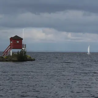 A red wooden lookout on a small jetty out in the grey water of Lough Neagh