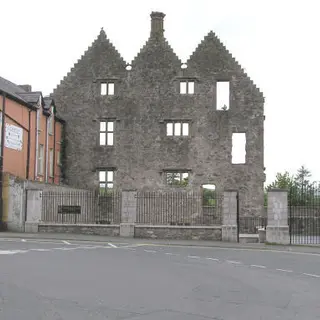 The ruined stone front of Newtownstewart Castle with its three stepped gables facing the street