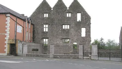 The ruined stone front of Newtownstewart Castle with its three stepped gables facing the street