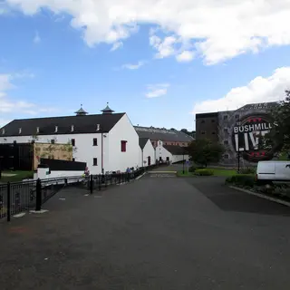 The whitewashed buildings and red pagoda roofed tower of the Old Bushmills Distillery