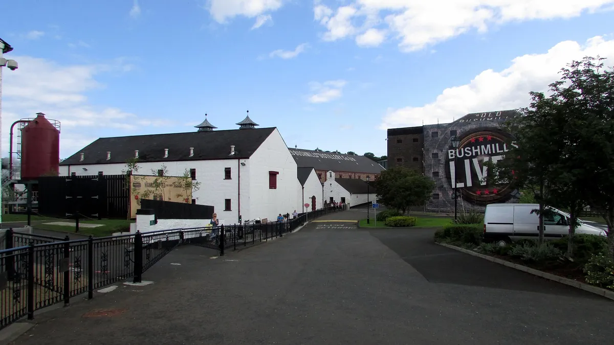 The whitewashed buildings and red pagoda roofed tower of the Old Bushmills Distillery