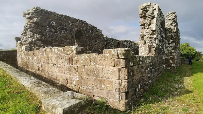 The roofless stone walls of Banagher Old Church standing in grass