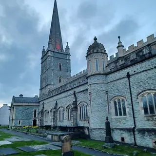 St Columb's Cathedral in Derry with its tall spire, seen from the churchyard