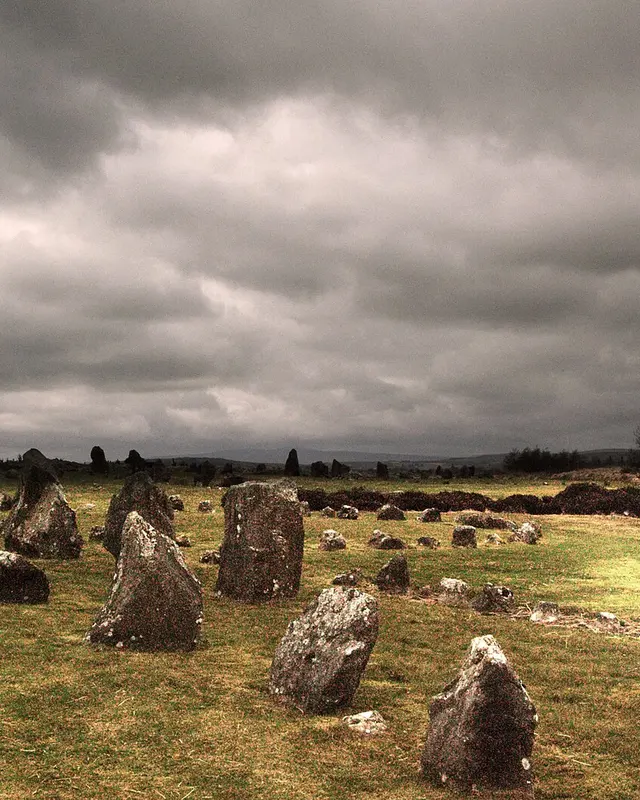 Standing stones scattered across the moor at Beaghmore under a heavy grey sky
