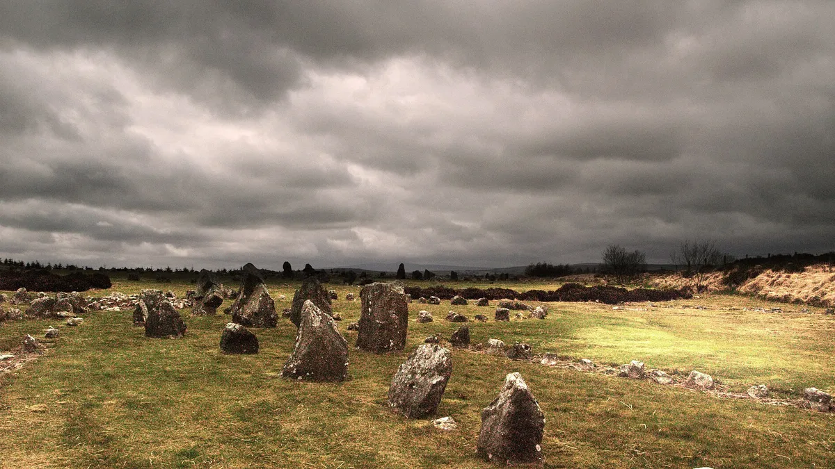 Standing stones scattered across the moor at Beaghmore under a heavy grey sky
