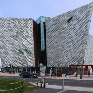 The angular silver facade of the Titanic Belfast building under a blue sky