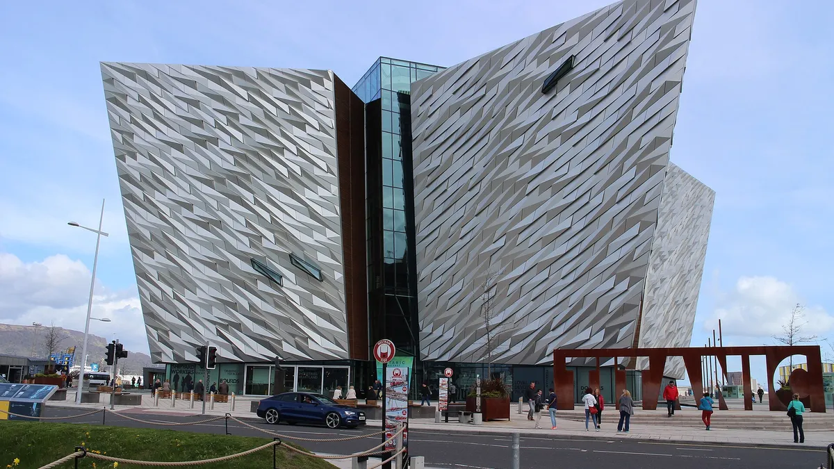 The angular silver facade of the Titanic Belfast building under a blue sky