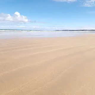 The wide, flat sand of Portstewart Strand under a clear sky