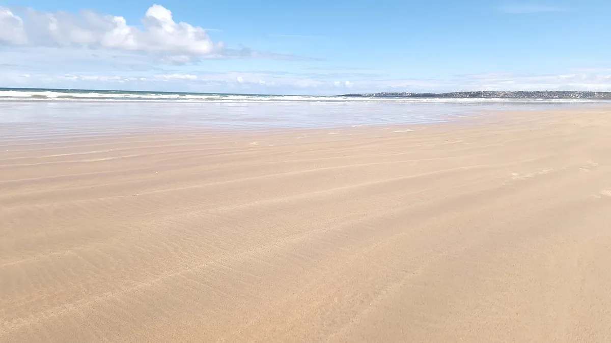 The wide, flat sand of Portstewart Strand under a clear sky