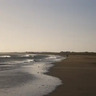 The long flat beach at Bettystown at dusk with the tide out