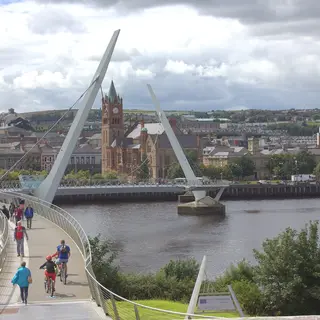 The Peace Bridge curving across the Foyle towards the Guildhall clock tower