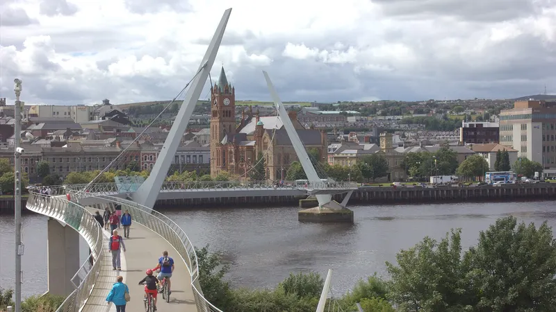 The Peace Bridge curving across the Foyle towards the Guildhall clock tower