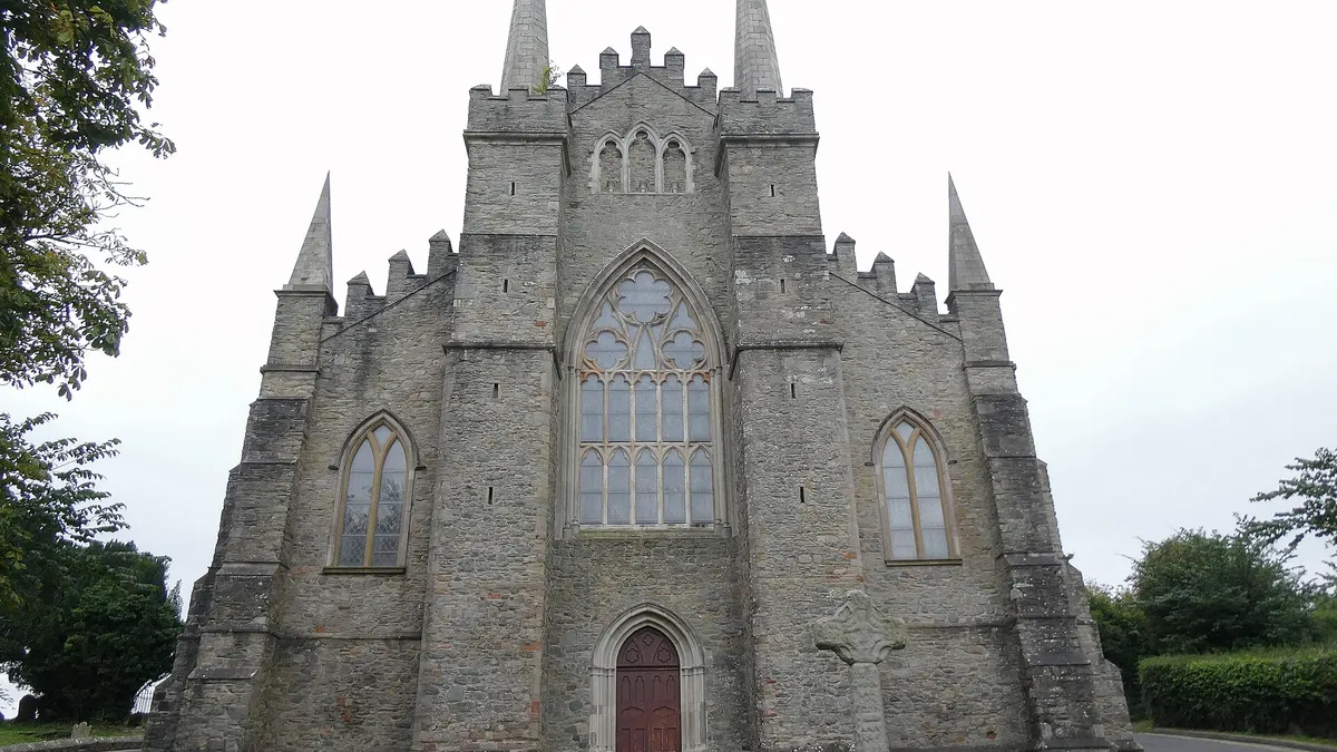 The grey stone west front of Down Cathedral with its pinnacles and a large pointed window